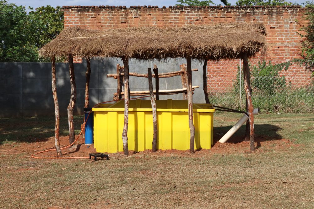 A SPARK digester under a thatched shelter